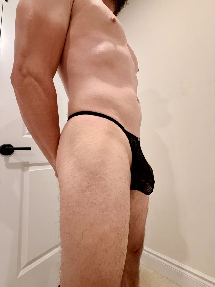 Him in a black lace thong, side view